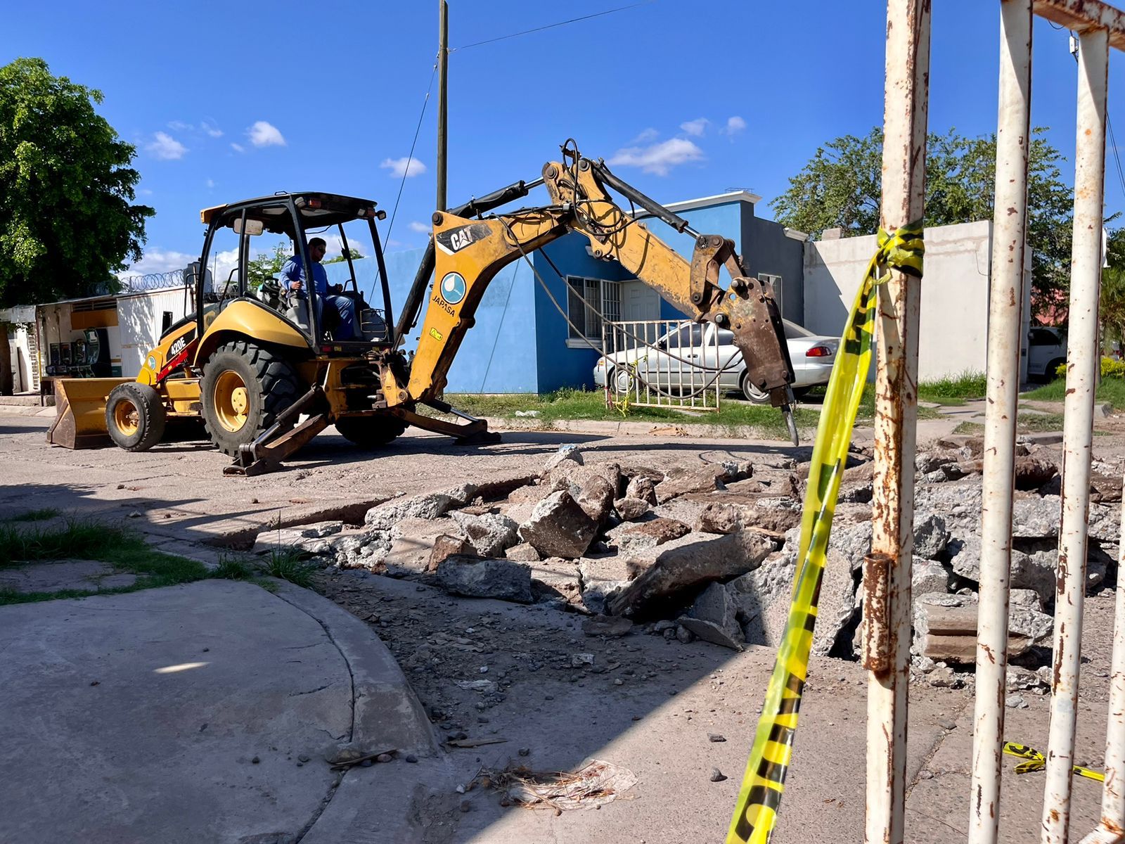 Máquina retroexcavadora realizando demolición de calle para la reconstrucción de la misma