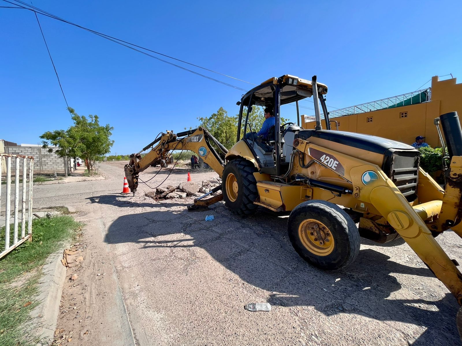 Máquina retroexcavadora realizando demolición de calle para la reconstrucción de la misma