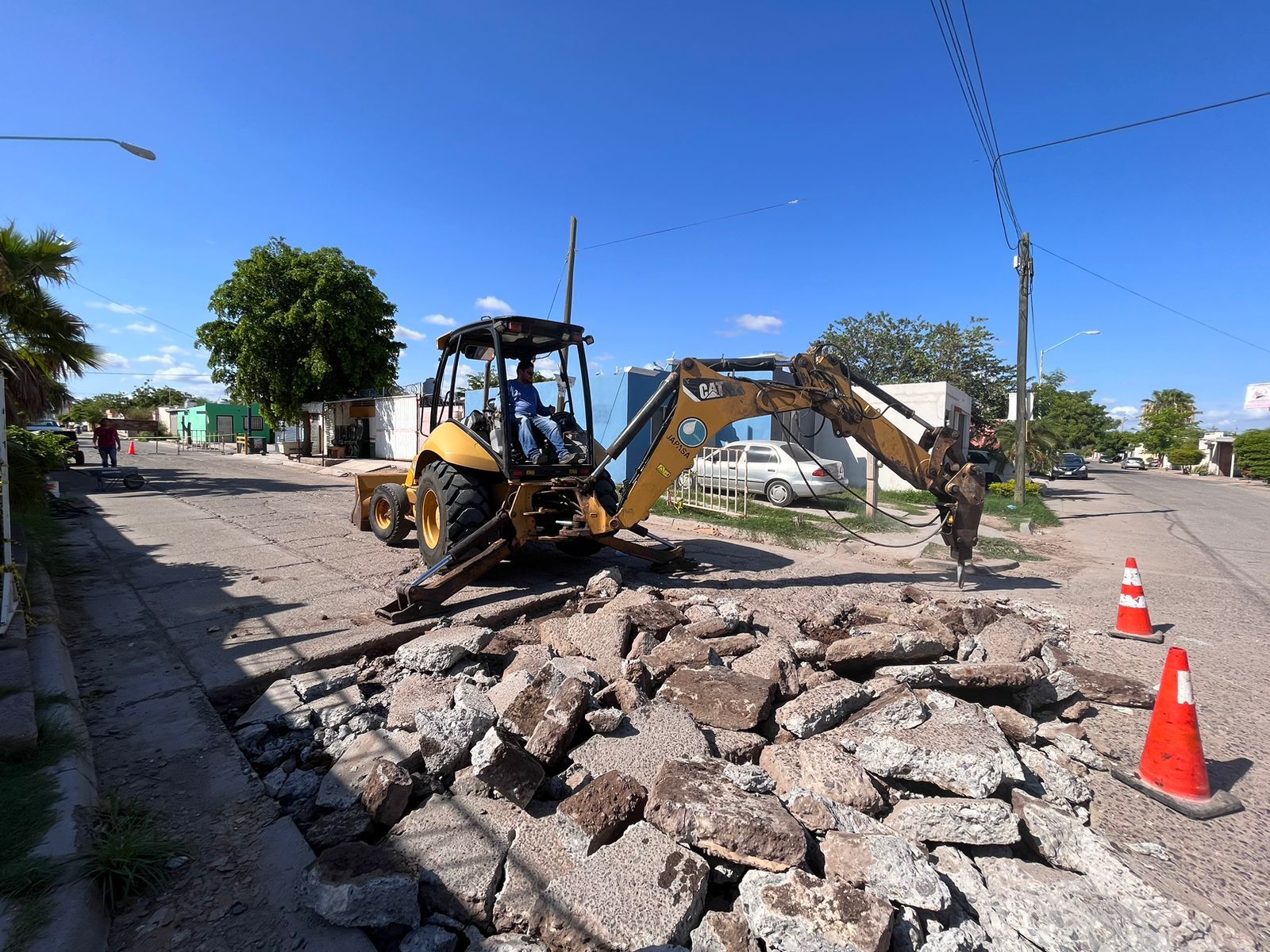 Máquina retroexcavadora realizando demolición de calle para la reconstrucción de la misma