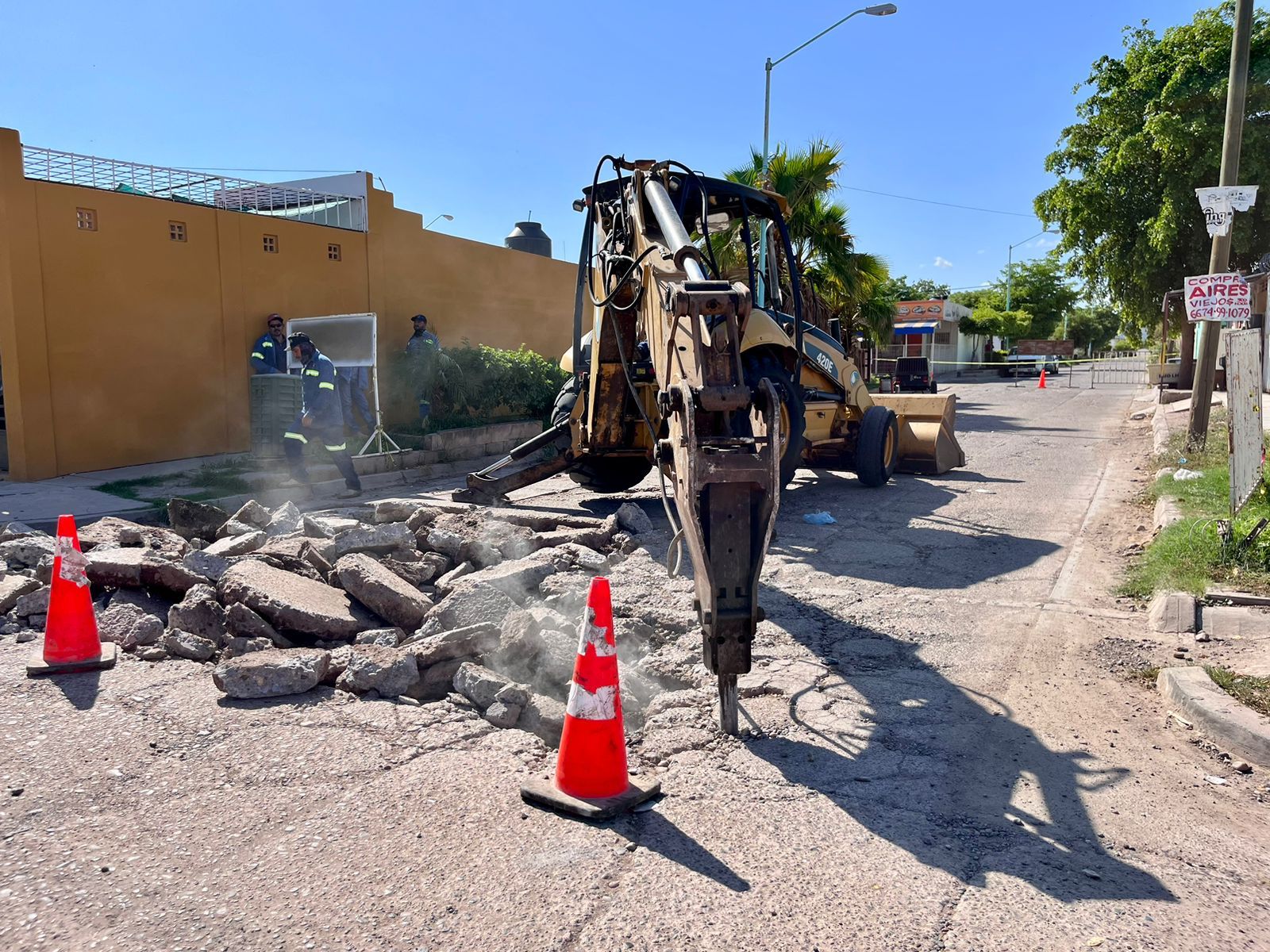 Máquina retroexcavadora realizando demolición de calle para la reconstrucción de la misma