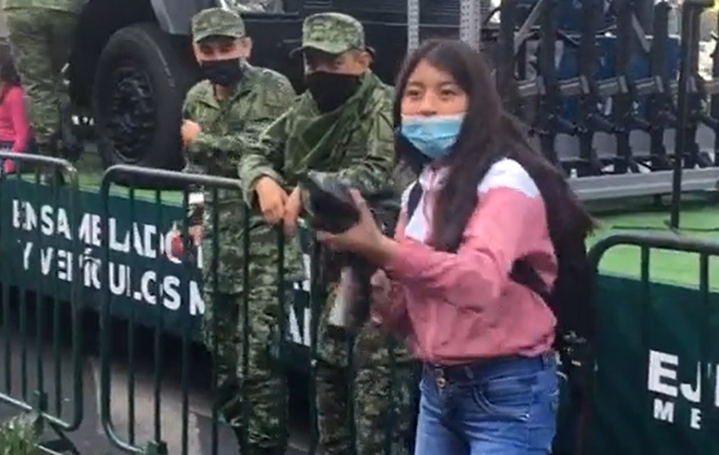 Jóvenes posando con armas del Ejército. Captura de Pantalla